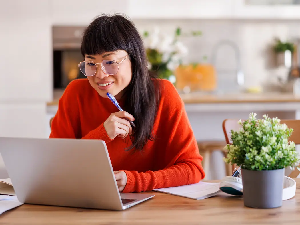 Woman on laptop with pen